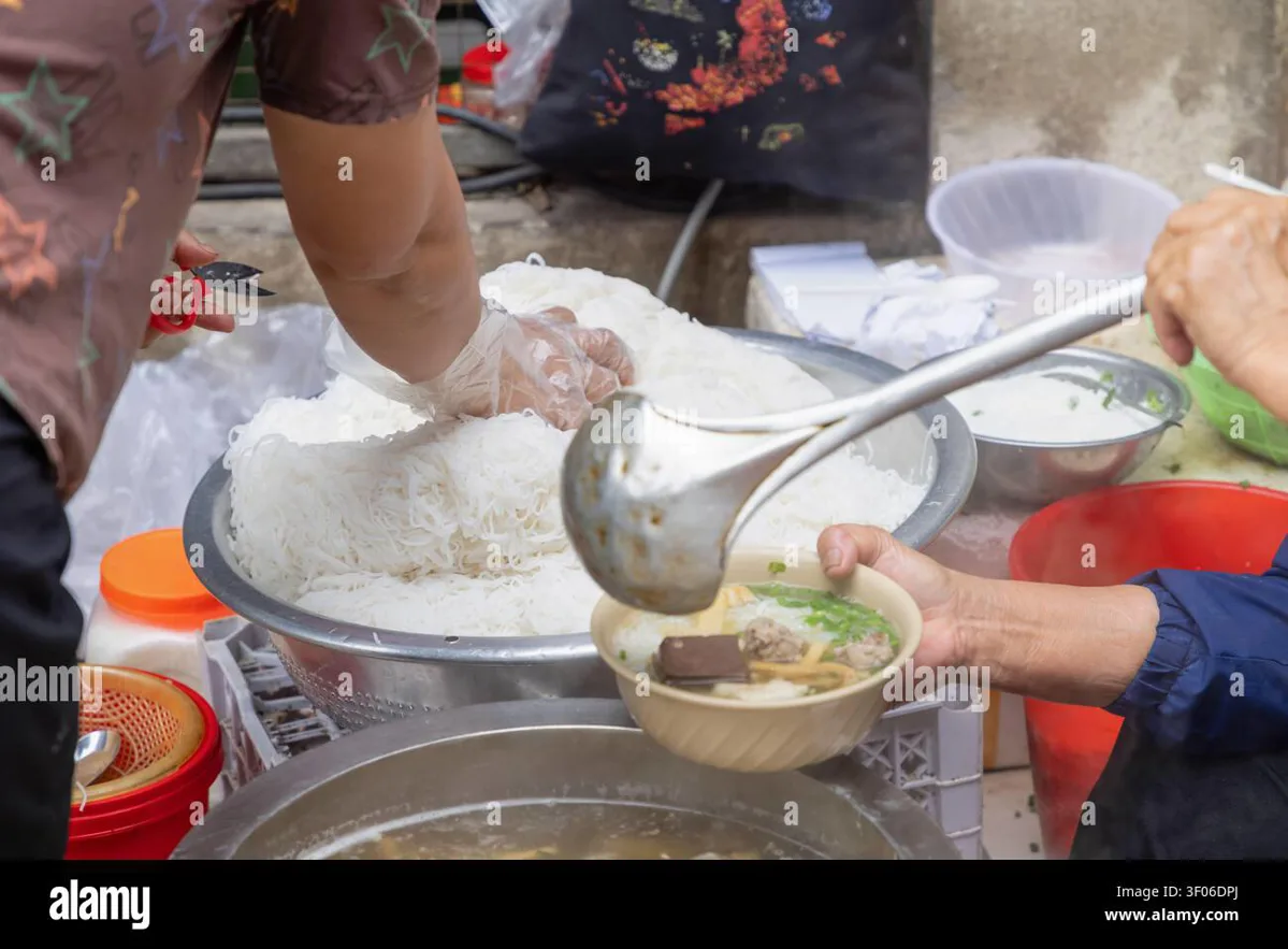 Hot bowl of pho being served by a street vendor