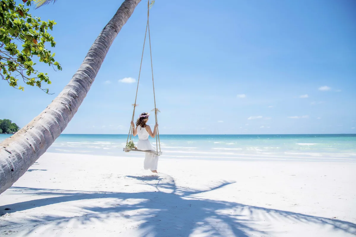 Wide tropical beach on Phu Quoc Island with sand, palms and calm blue sea