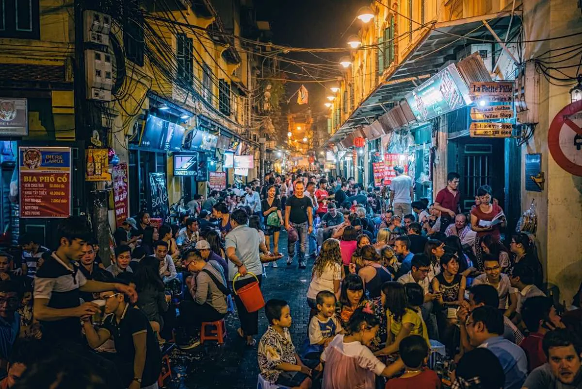 Nighttime Pham Ngu Lao backpacker district street with shops and motorbikes