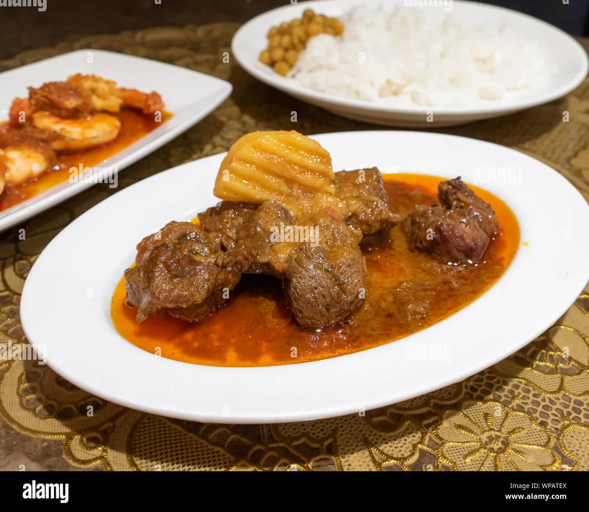 Burmese curry served with multiple small side dishes and dips