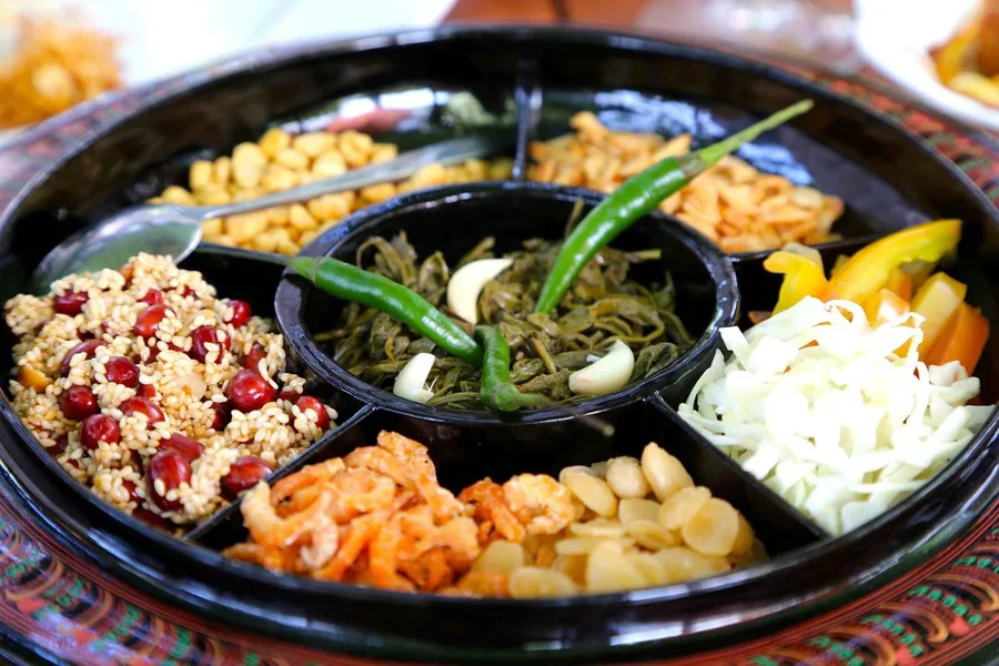 Fermented tea leaf salad with cabbage, tomatoes, nuts and peas