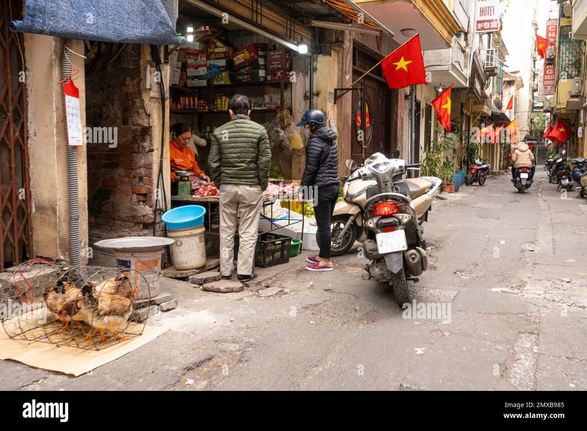 Narrow lane in Hanoi's Old Quarter with scooters and street vendors