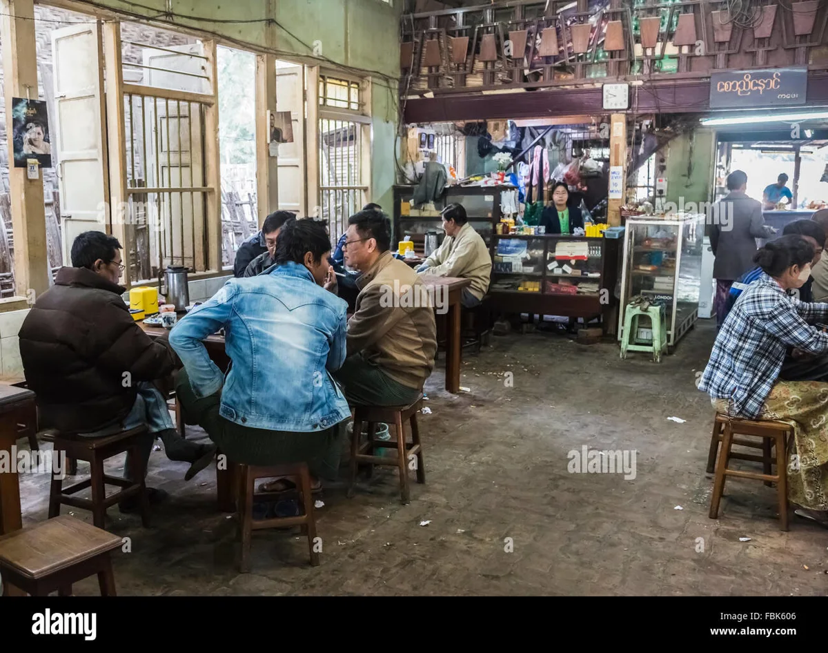 Interior of a Burmese tea shop with low tables and tea cups