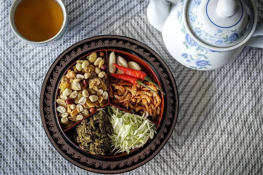 Fermented tea leaf salad with cabbage, tomatoes, nuts and peas