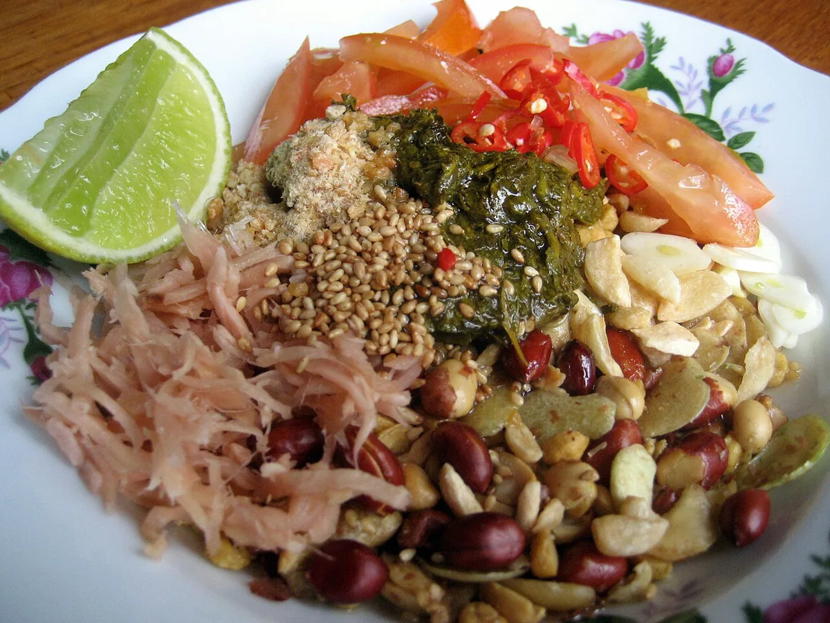 Fermented tea leaf salad with cabbage, tomatoes, nuts and peas