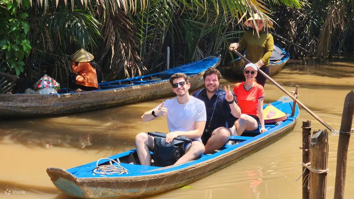 Longtail boats on a narrow waterway surrounded by greenery in the Mekong Delta