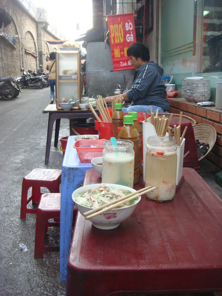 Hot bowl of pho being served by a street vendor