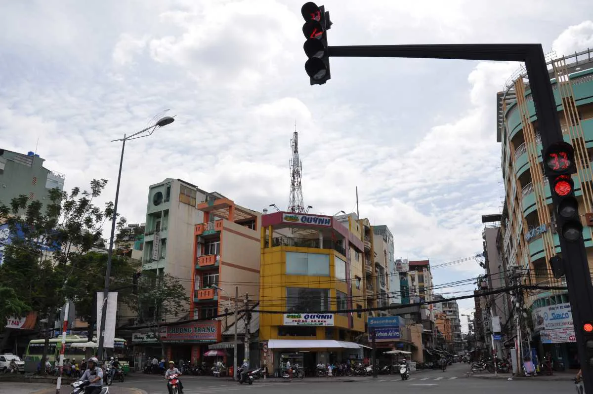 Nighttime Pham Ngu Lao backpacker district street with shops and motorbikes