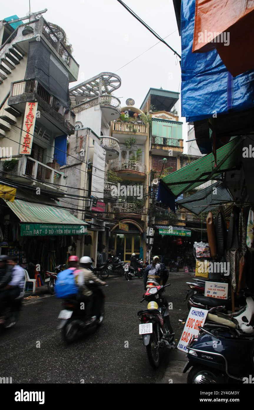 Narrow lane in Hanoi's Old Quarter with scooters and street vendors