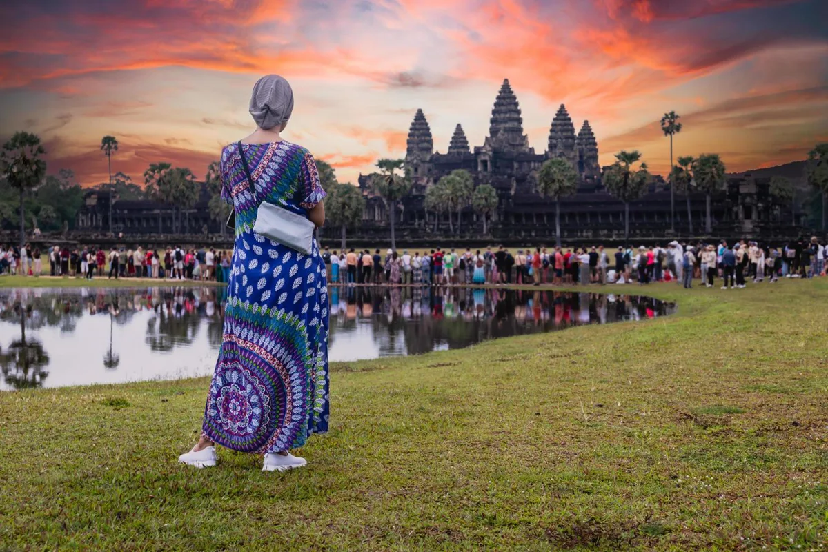 Angkor Wat temple silhouetted at sunrise with reflection pools