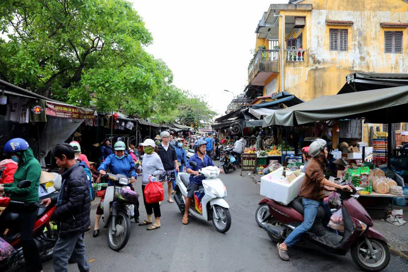 Crowded Vietnamese street filled with motorbikes at sunset