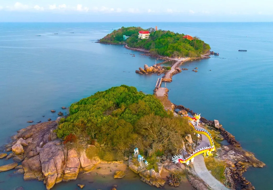 Panoramic view of Ca Mau Cape, Vietnam's southernmost point, with a symbolic landmark and vast mangrove forests.