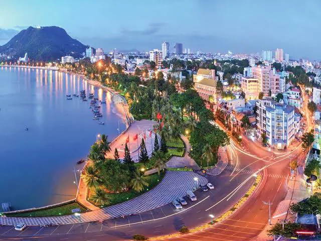 Panoramic view of Vung Tau city and coastline from the Christ the King statue, showing beaches, mountains, and urban areas.