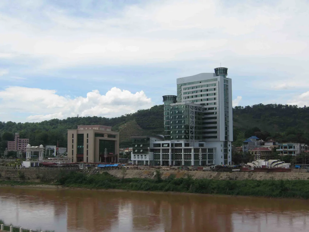 Panoramic view of Lao Cai City with the Red River and mountains in the background, showcasing its vibrant urban landscape.